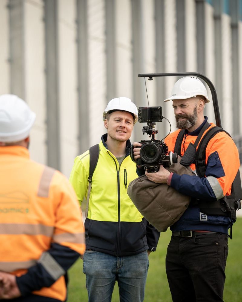 Interviewing a civil contractor in hard hats beside a new wall