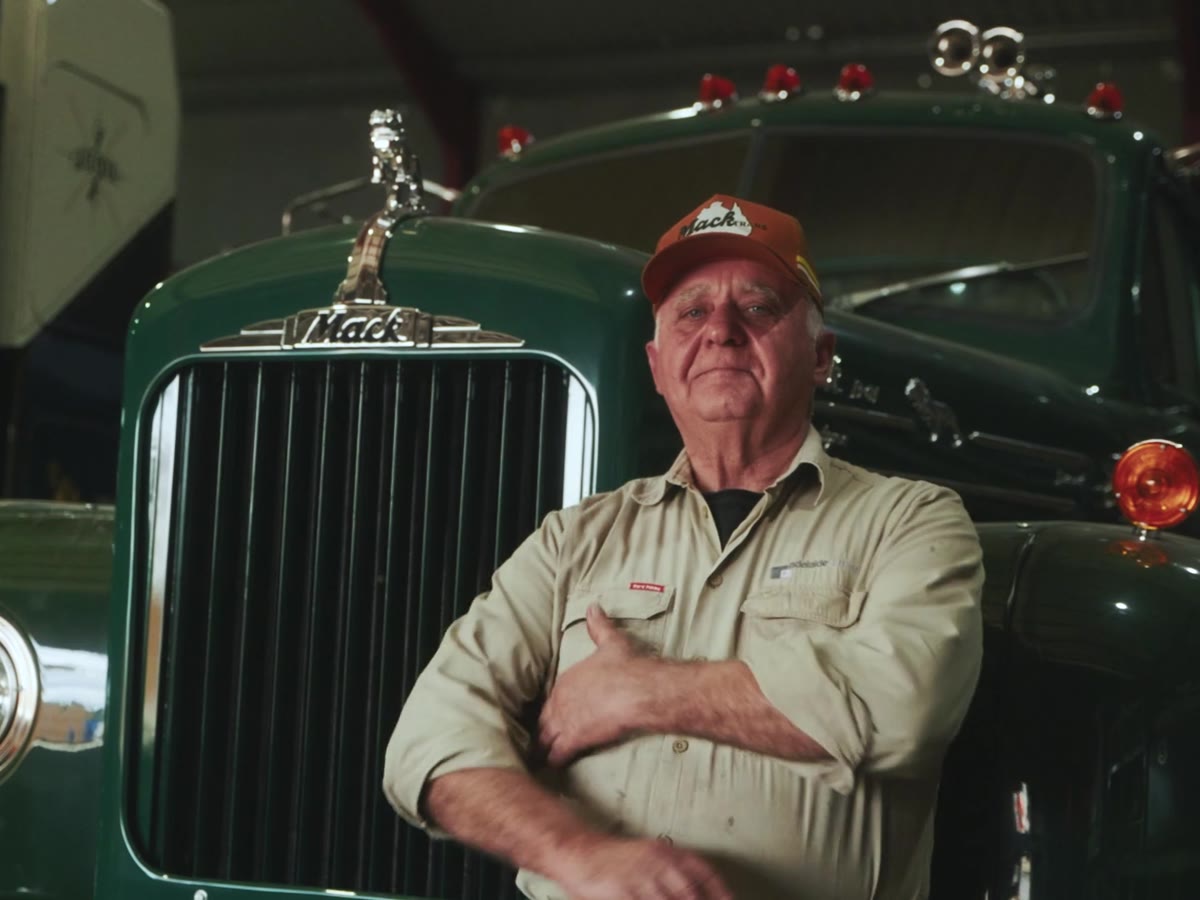 The founder of Adelaide Kerbing, arms crossed in front of his green Mack truck