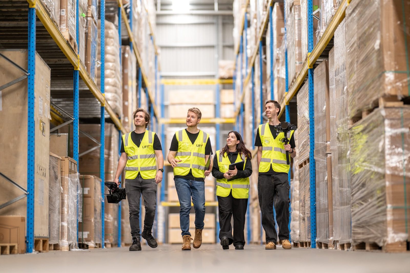 The Lift crew walking through a warehouse in hi-vis vests with their cameras