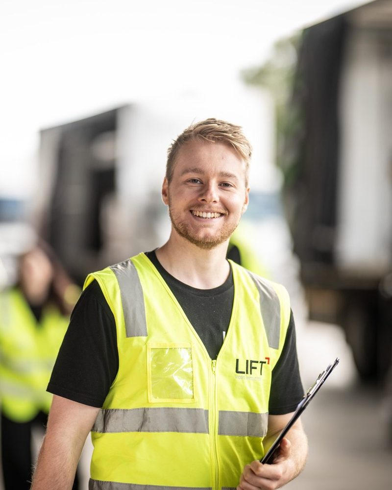 Grant Jamison, Founder and Director at Lift Video Production, holding a clipboard in a transport yard