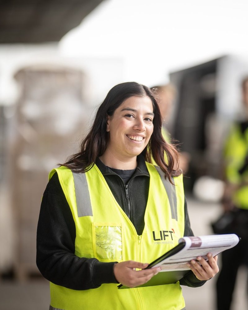 Gisele Kieffer, Production Coordinator at Lift Video Production, holding a script folder in a transport yard