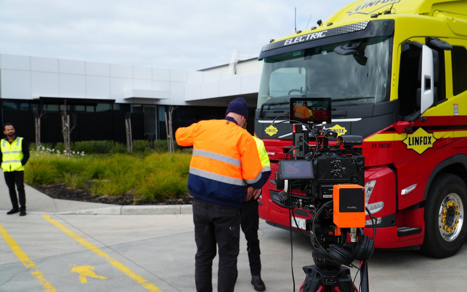 A Lift cinematographer filming a driver beside an electric prime mover at Laverton