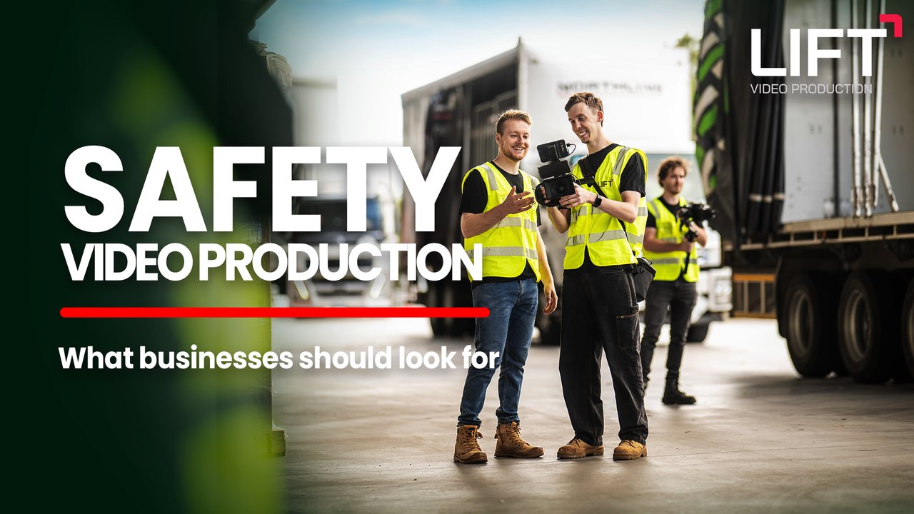 Three of the Lift crew in hi-vis vests checking a camera beside trucks in a yard, with the words Safety video production, what businesses should look for